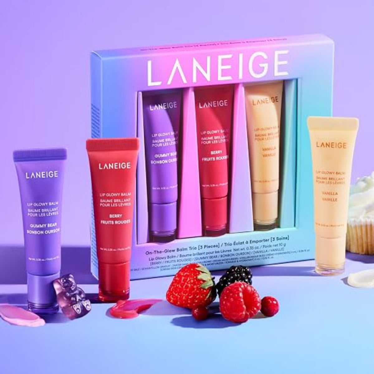 LANEIGE Lip Glowy Balm Trio Set box with Berry, Gummy Bear and Vanilla tubes on a purple background.