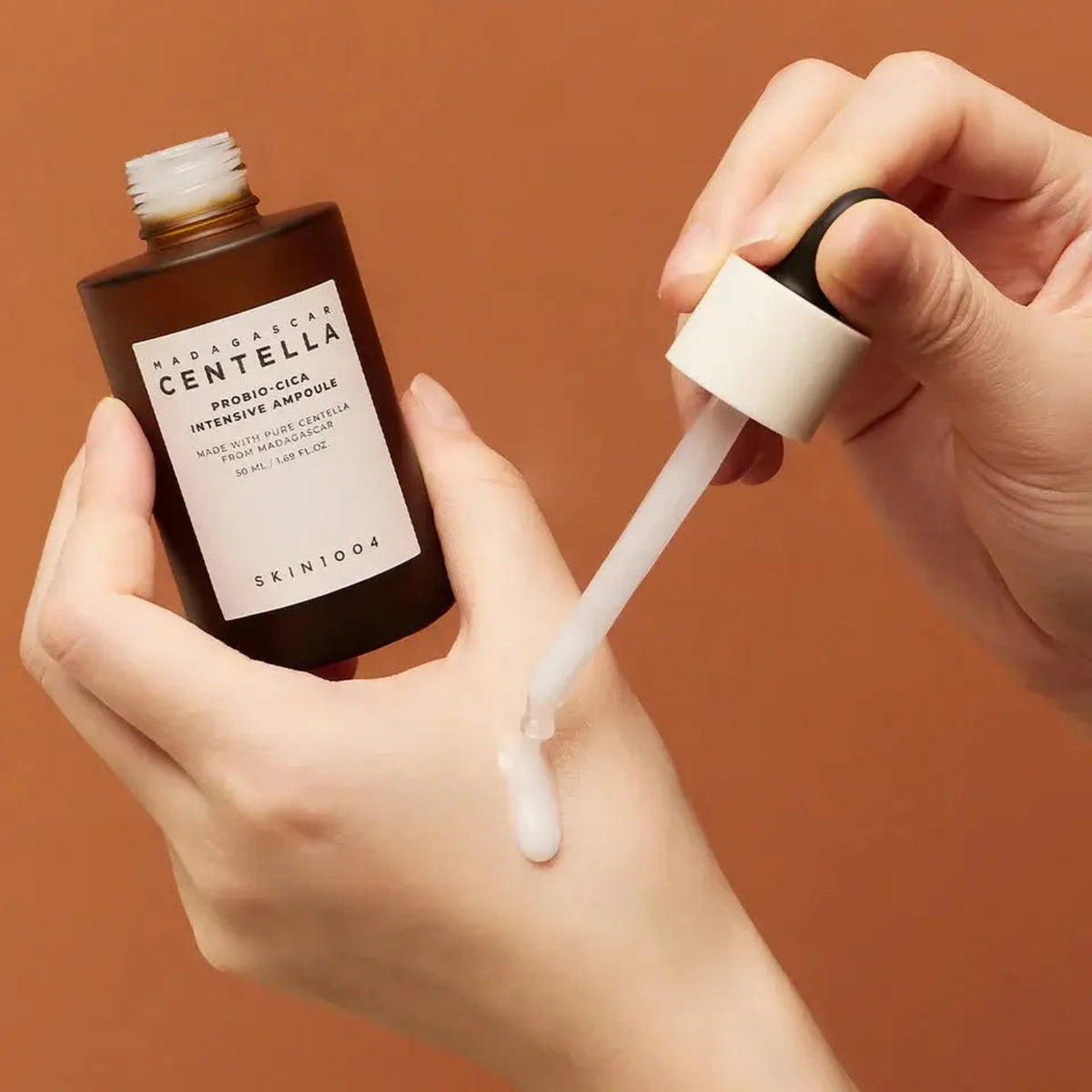 Dropper applying SKIN1004 Madagascar Centella Probio-Cica Intensive Ampoule to the back of a hand