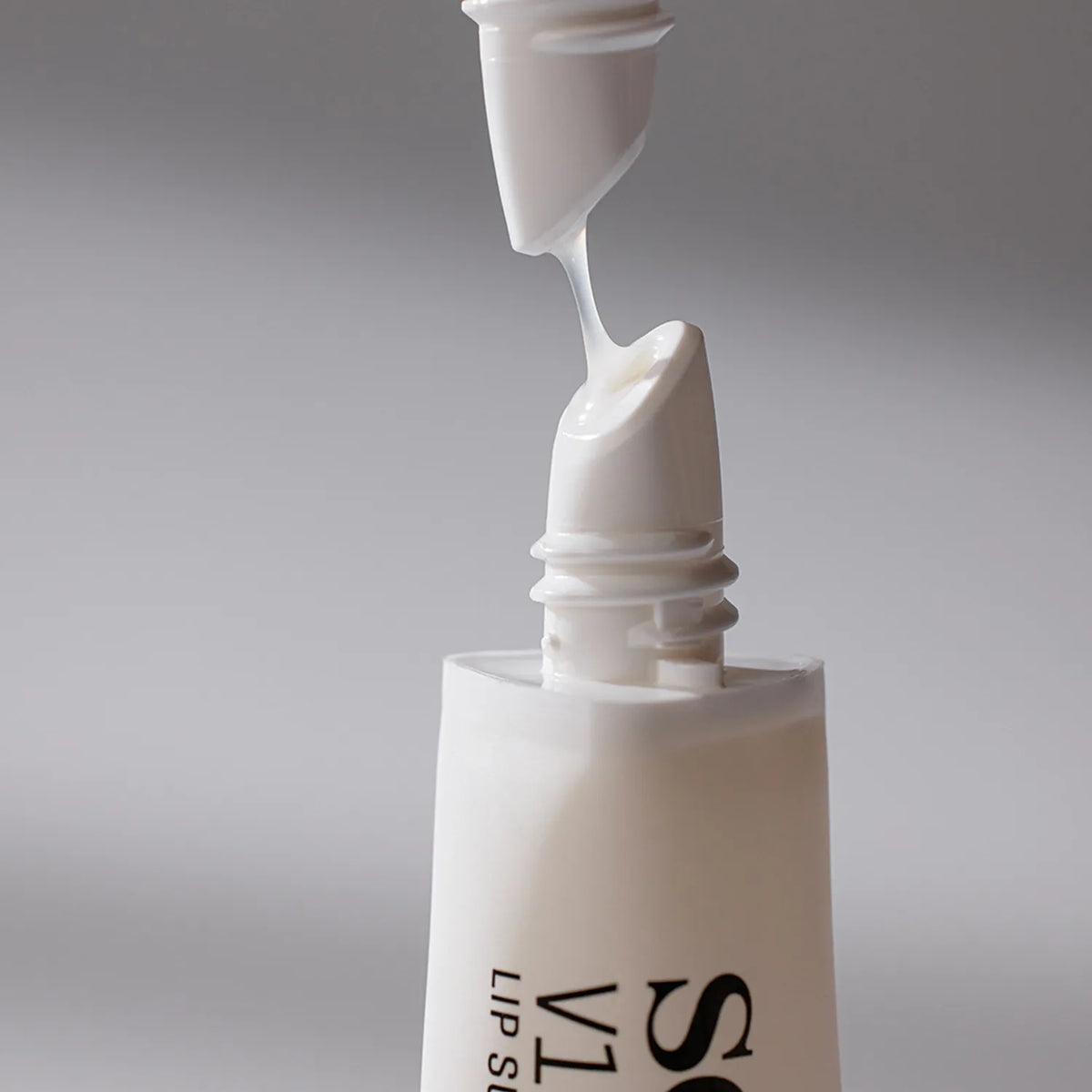 SOME BY MI - Close-up of a skincare product being applied with a applicator on a gray background
