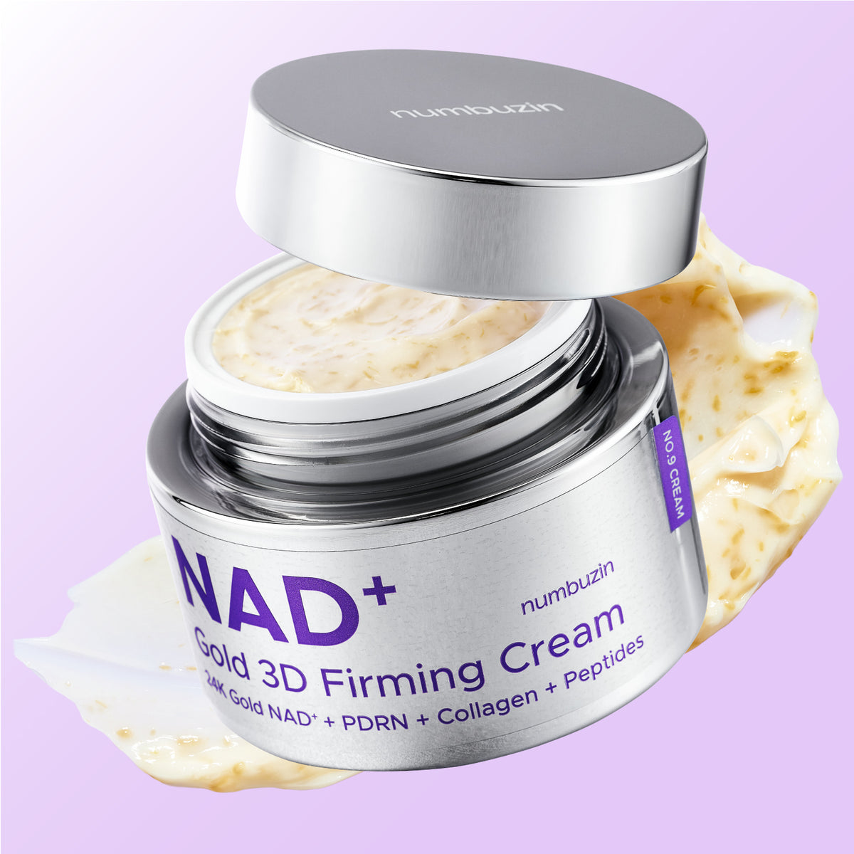 An open silver jar of numbuzin NAD+ Gold 3D Firming Cream, showing the pale cream product inside, with a dollop of the cream on a light purple background.