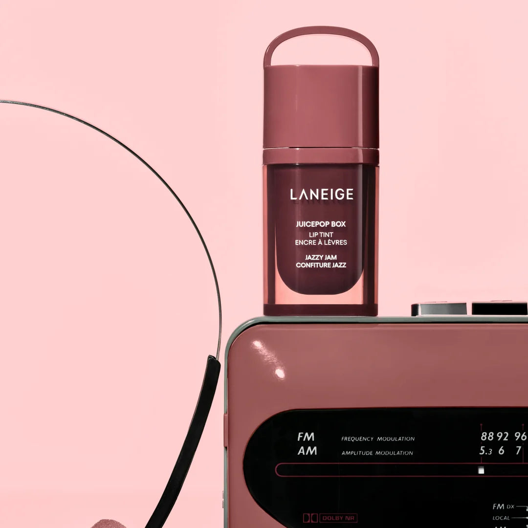 LANEIGE JuicePop Box Lip Tint Jazzy Jam beside a radio on a pink background.