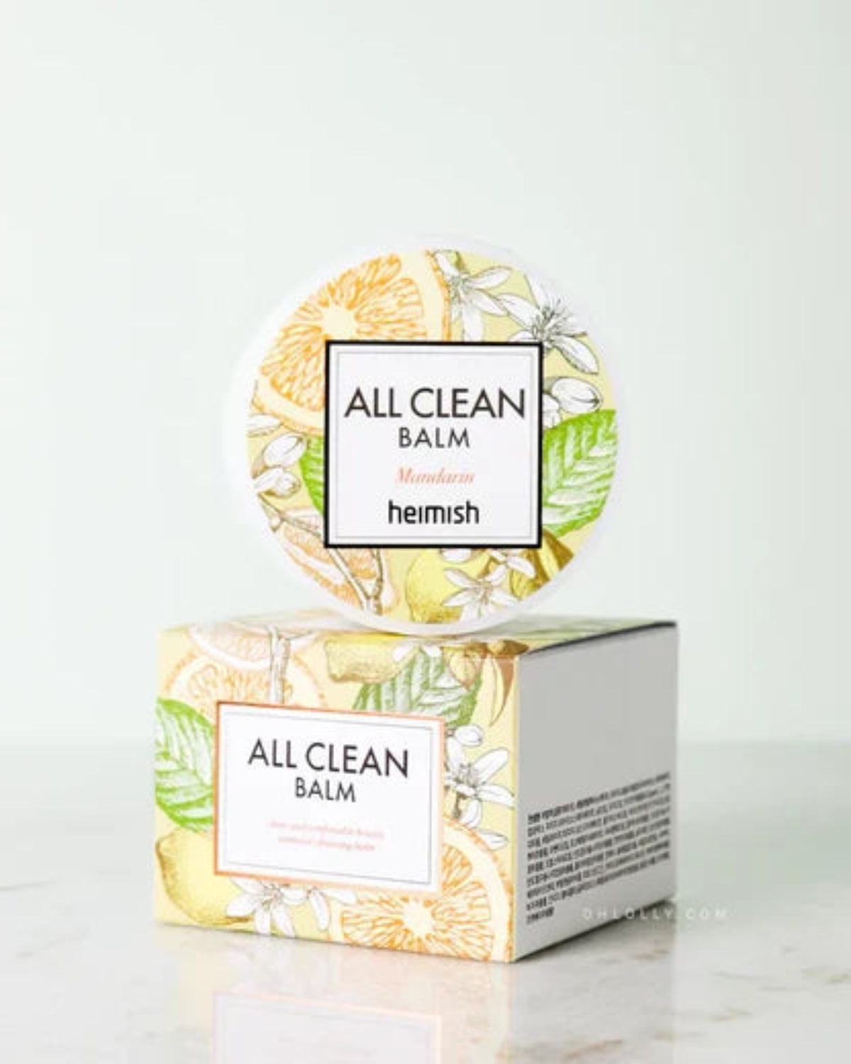 HEIMISH All Clean Balm Mandarin 50ml product image. A round tin of Heimish All Clean Balm with a matching illustrated box, displayed on a light marble surface against a white background.