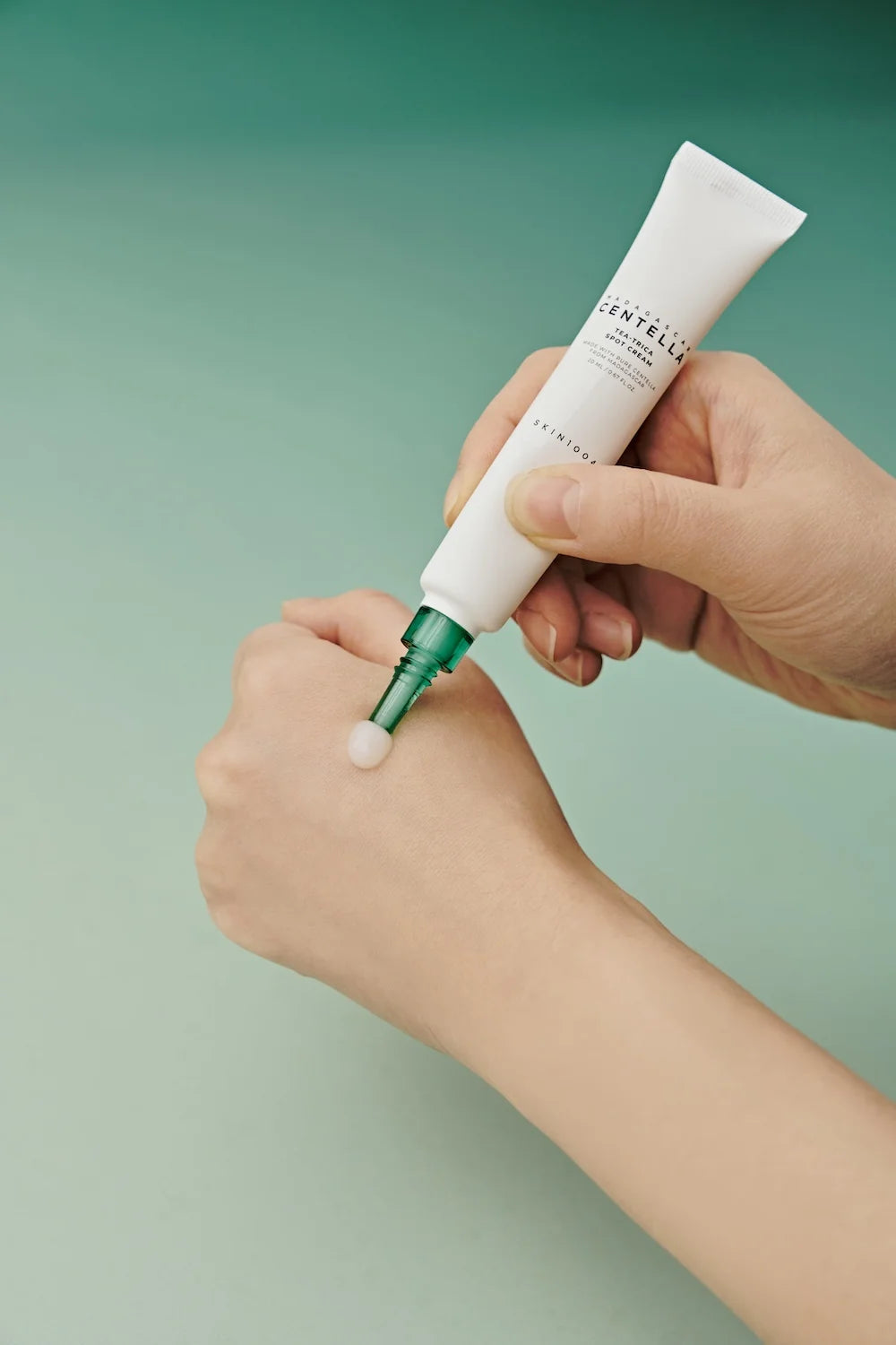 SKIN1004 Tea-Trica Spot Cream is being applied from the tube